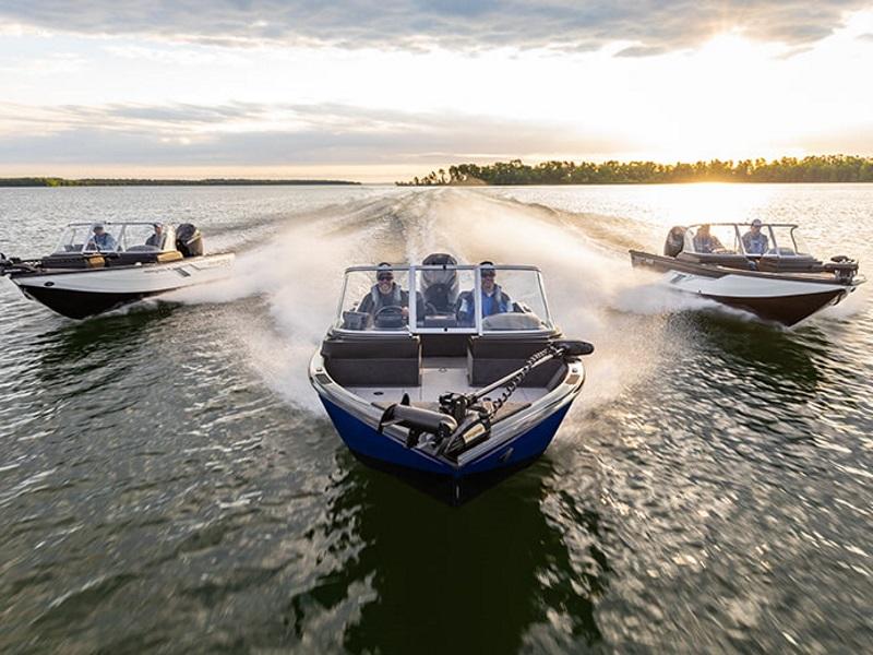 Three Crestliner® Fish Hawk Walk-through JS fishing boats going down the lake with the sunset on …